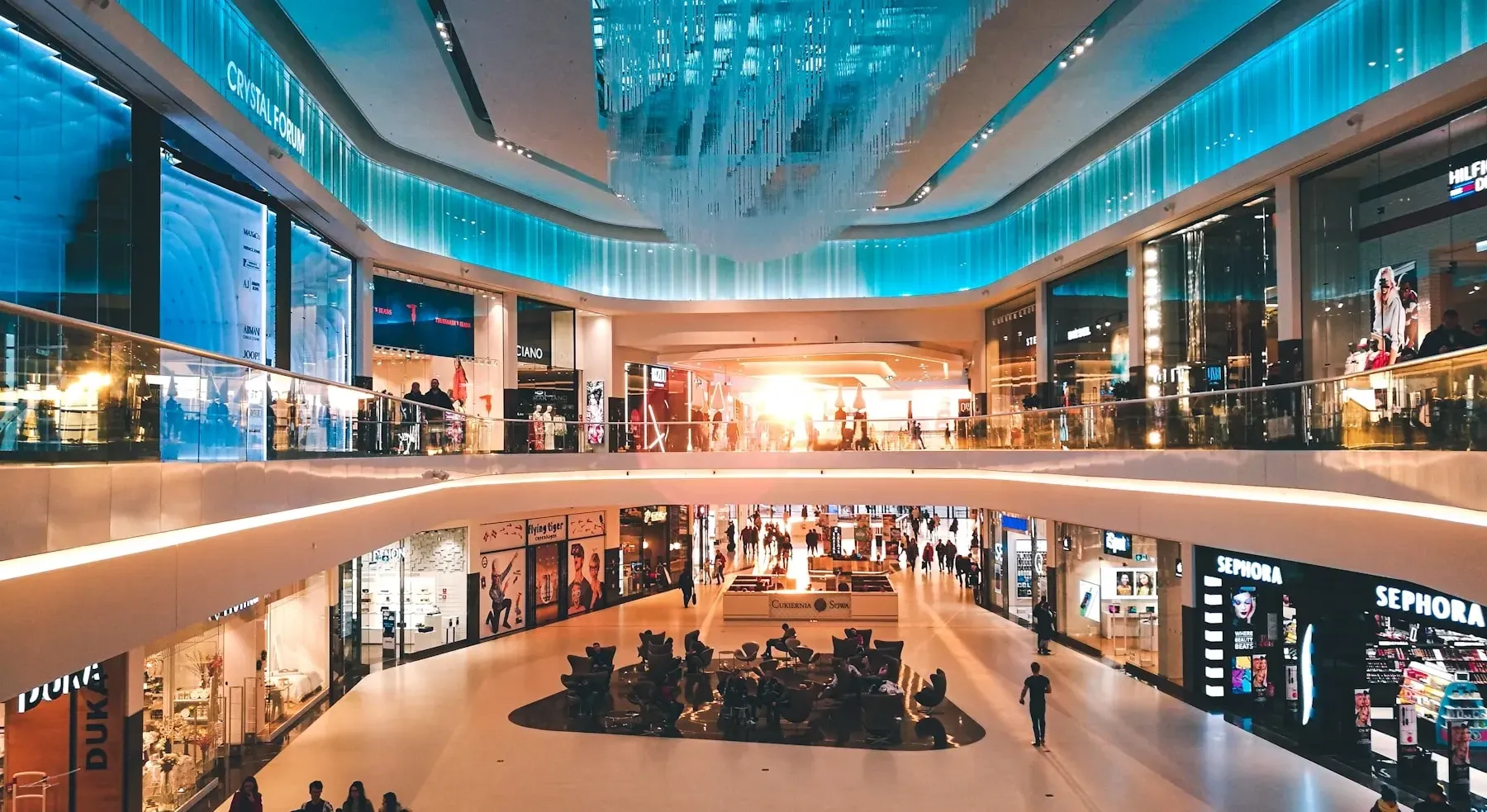 An illuminated shopping and entertainment arcade at night