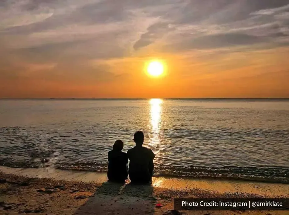 Couple enjoy sunset view at Blue Lagoon Beach Port Dickson