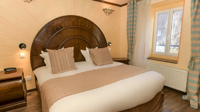 Chambre élégante avec lit grand confort et fenêtre à l'Hôtel Villa Aultia.