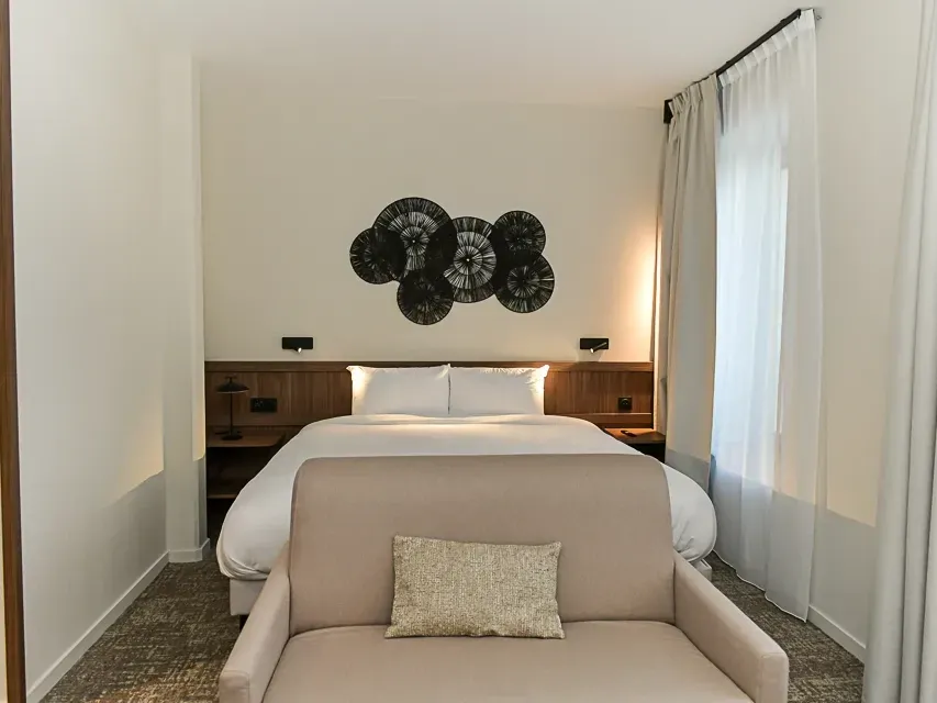 Chambre Comfort avec lit et fauteuil à l'Hôtel Rivella à Clisson.