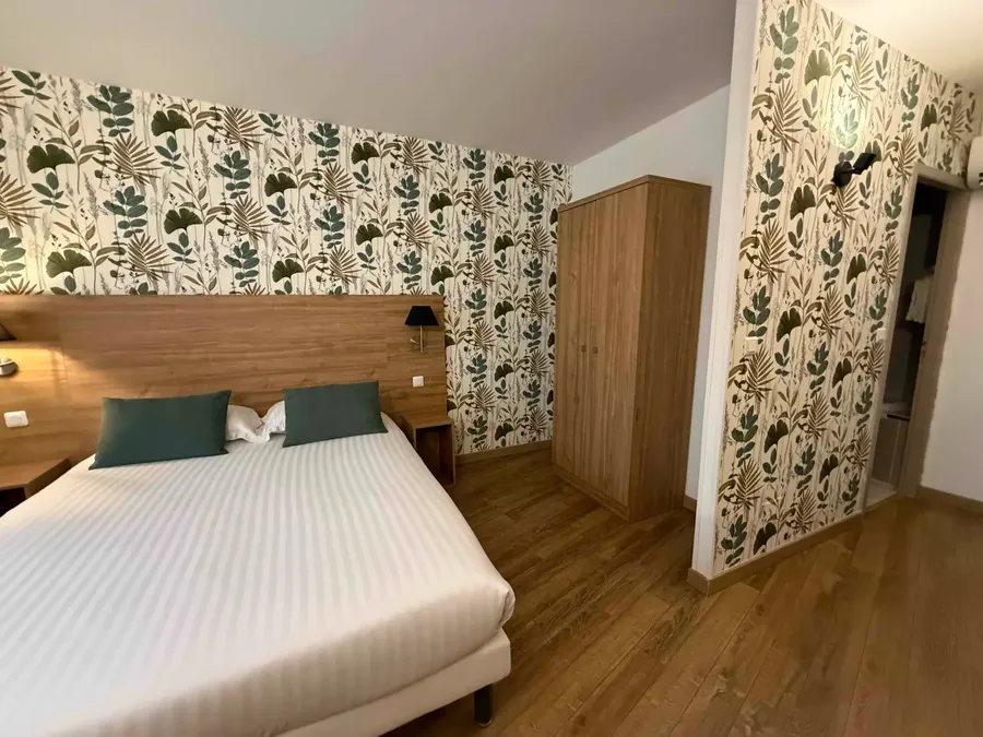 Chambre classique avec décoration tropicale et parquet au Grand Hôtel Molière de Pézenas.