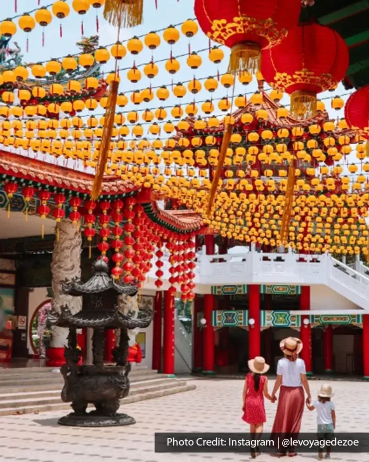 Family walking beneath hanging lanterns at Thean Hou Temple