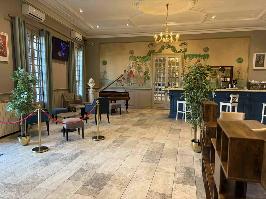 Salle élégante avec piano et bar au Grand Hôtel Molière.