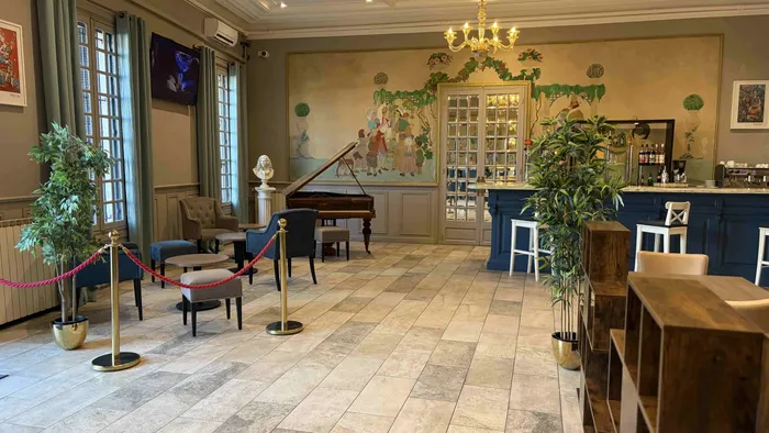 Salle élégante avec piano et bar au Grand Hôtel Molière.