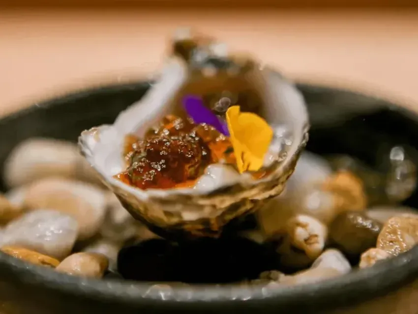 Oyster dish at Hidden Omakase Miami with garnish and plating