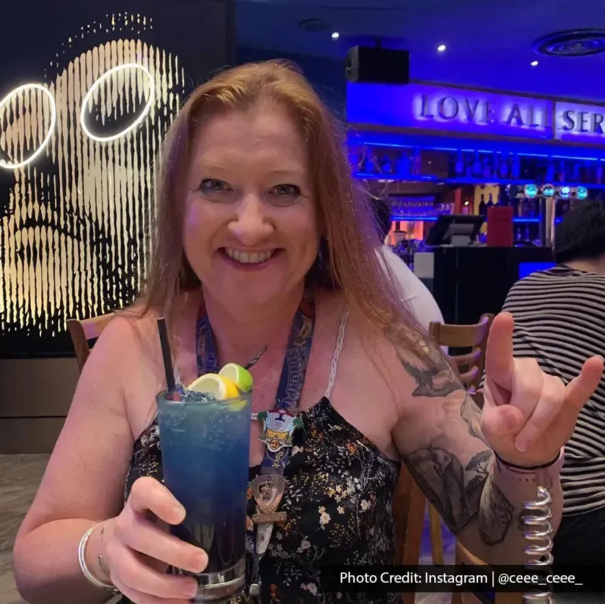 Woman enjoying a colorful drink in the vibrant atmosphere of Hard Rock Cafe Penang.