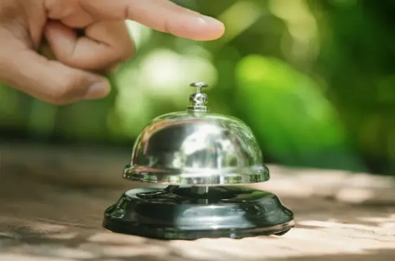 A person pointing at the call bell on the table - Grand Lexis Port Dickson