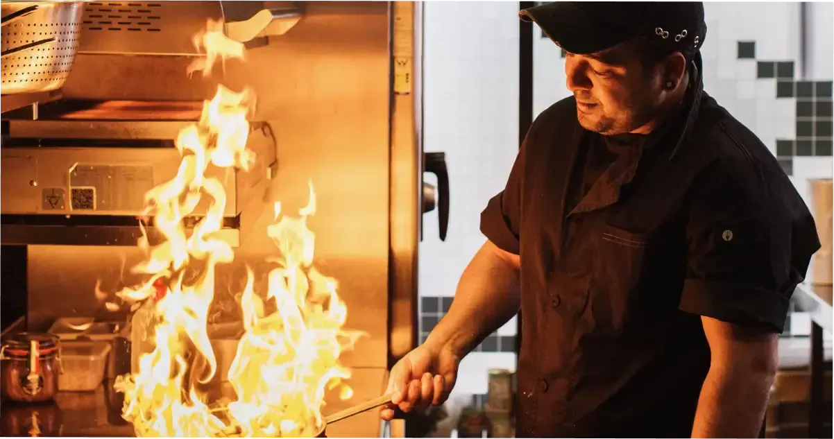 A chef cooking with fire at a restaurant in Adelaide Central Market.