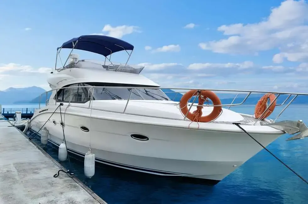 A white motor cruiser rests at the dock with calm water surrounding it - Lexis Hibiscus Port Dickson