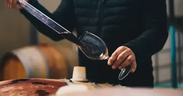 A winemaker filling a glass at a Hobart winery.