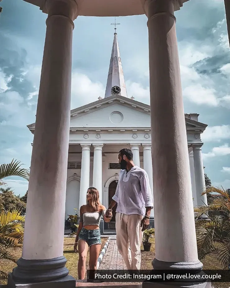 Couple walking towards St. George’s Church entrance between columns in George Town Penang.