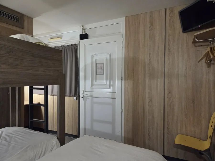 Chambre familiale triple avec lits superposés et télévision à Hôtel Aurillac Aéroport à Aurillac.