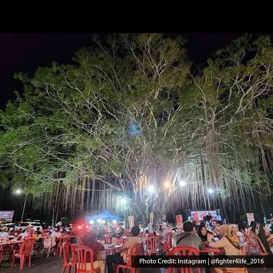 Night dining area at King’s Char Kuey Teow under large tree.