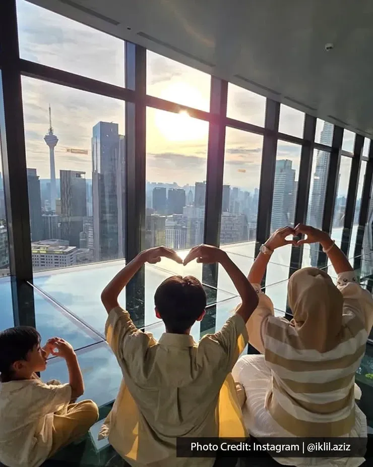 Family making heart gestures overlooking the Kuala Lumpur skyline