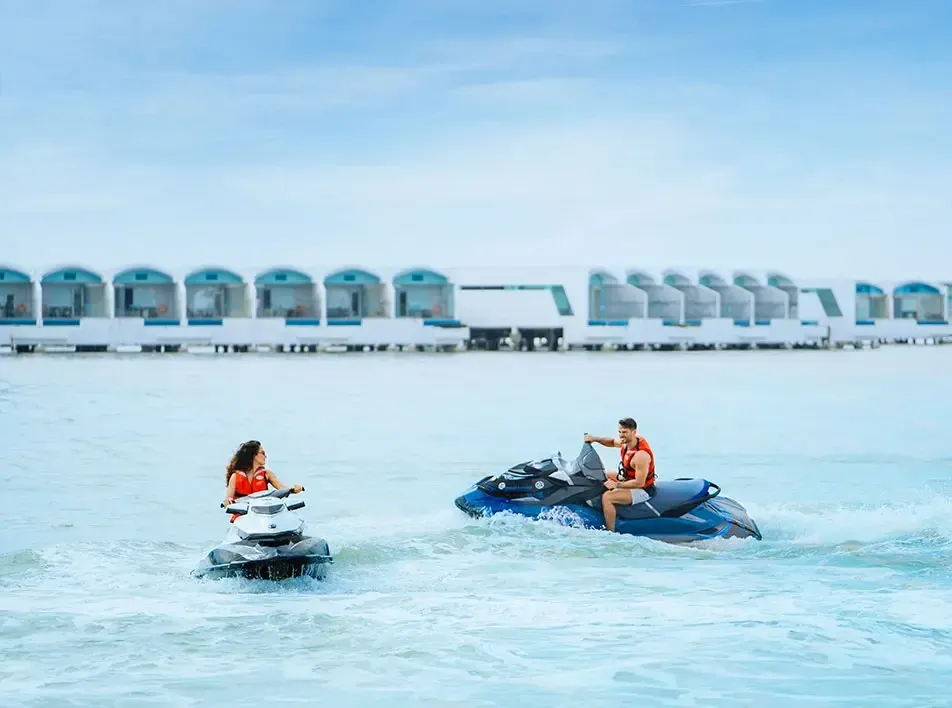Man and woman on jet skis sharing a fun water adventure near overwater resort – Lexis Hibiscus Port Dickson