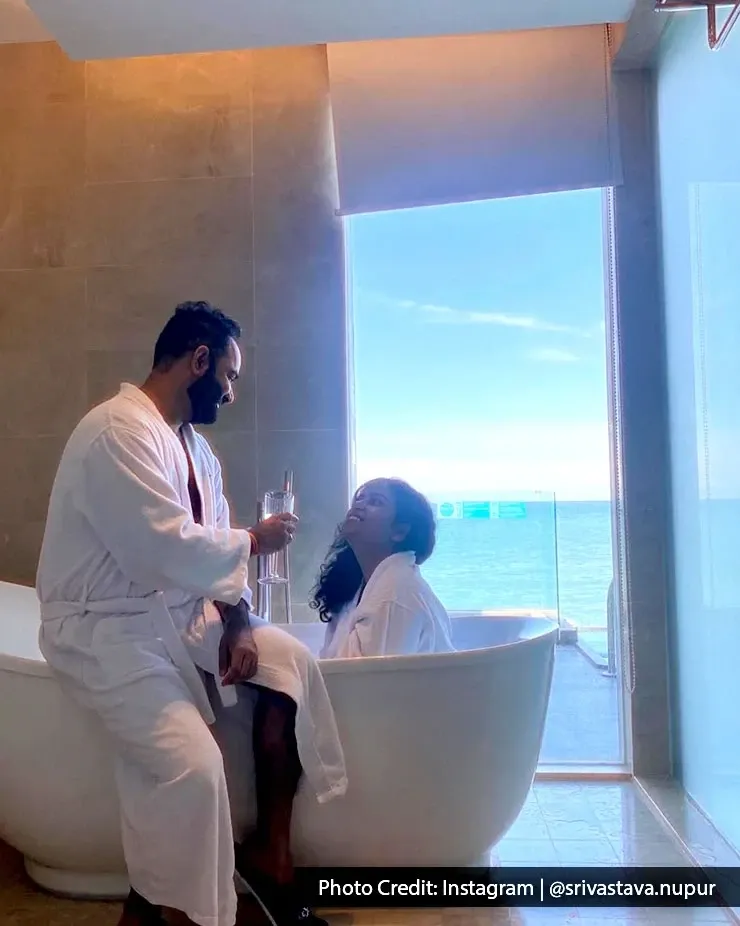 Romantic couple enjoying a private bath experience overlooking the sea.