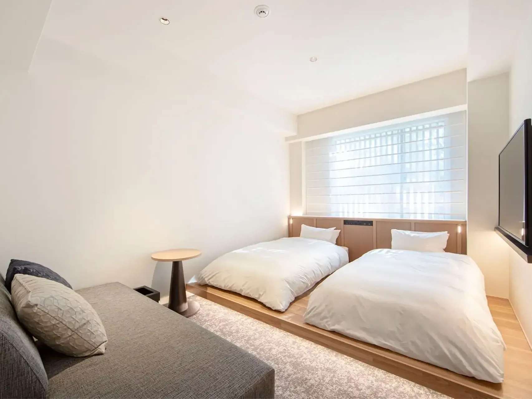 Two cozy beds and sitting area in Deluxe Twin at Park Hotel Kyoto