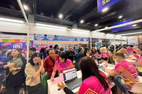 A large crowd gathers at MATTA FAIR, with a laptop displayed prominently in the foreground - Imperial Lexis Kuala Lumpur