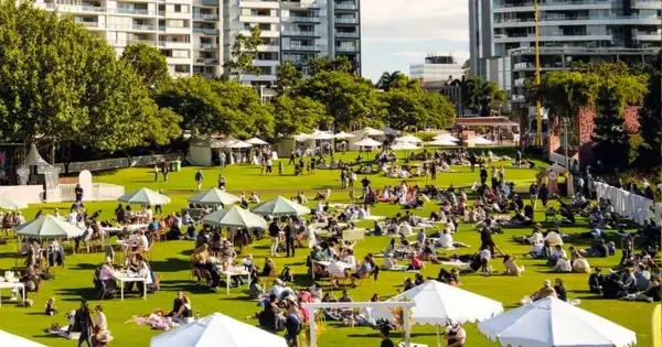 Patrons enjoying the sun under white pergolas at roma street parkland