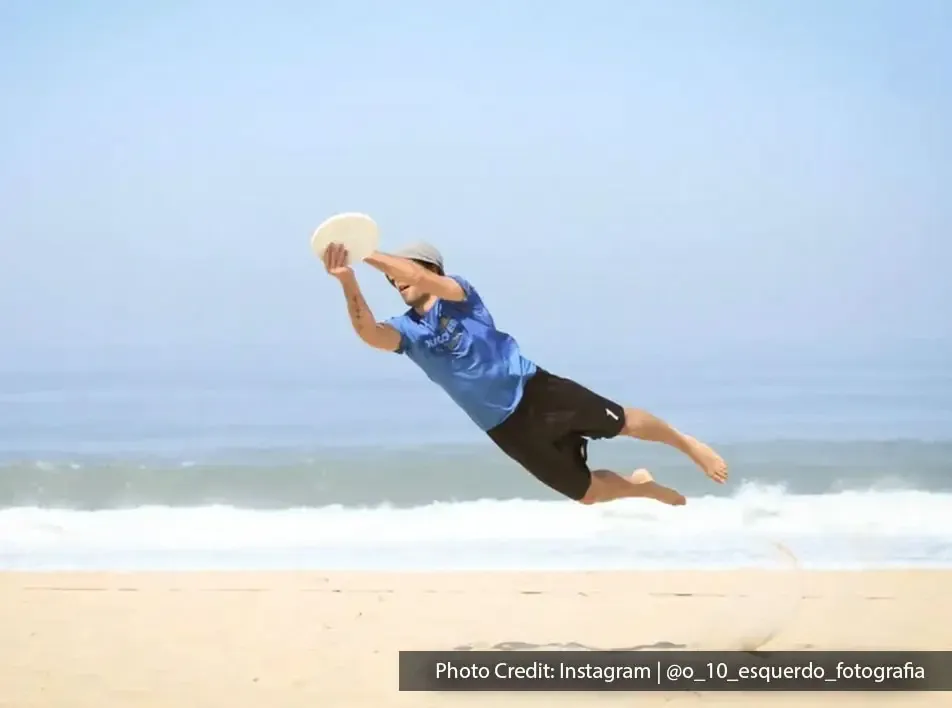 A man playing frisbee on the beach during his relaxing beach vacation - Lexis MY
