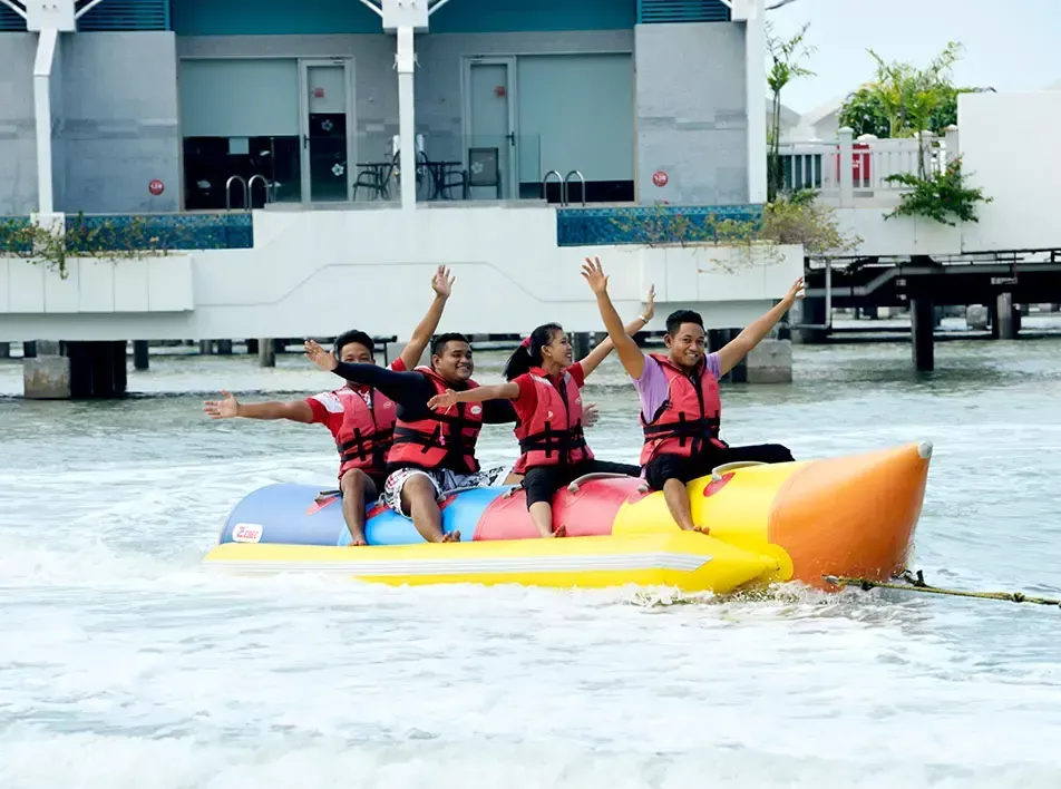 A group of people playing the banana boat - Lexis Hibiscus