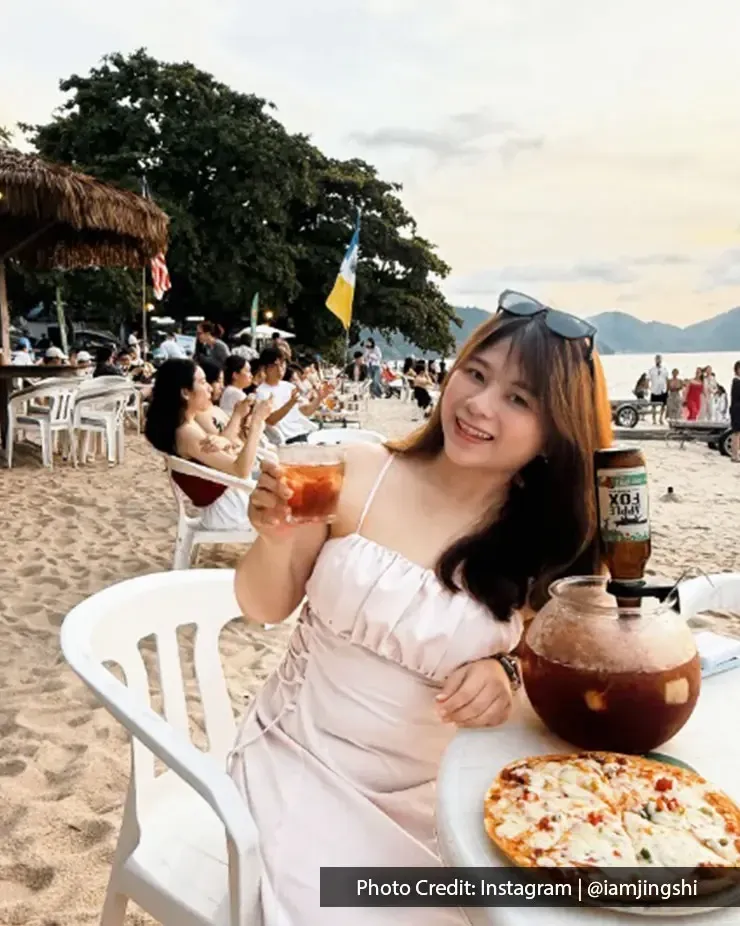 Woman enjoying a cocktail with pizza at BoraBora in Batu Ferringhi Penang.