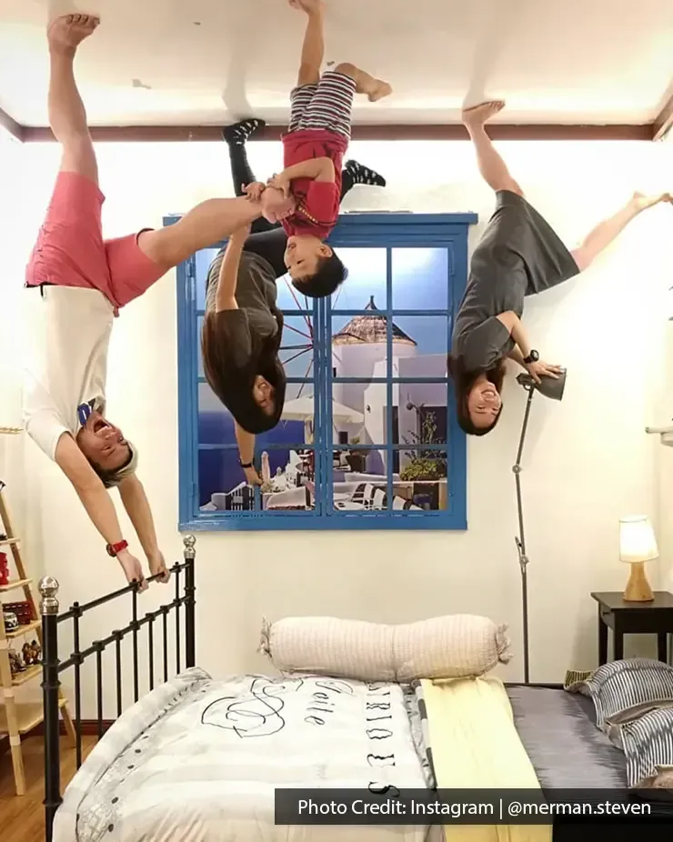 Playful family doing a pose in Upside Down Museum – Lexis Suites Penang