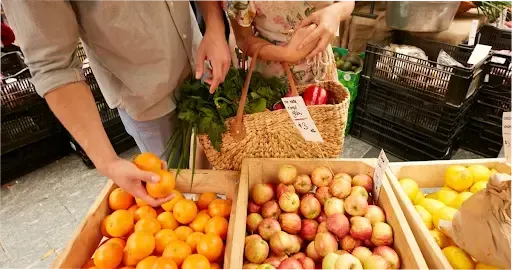 People picking up mandarins and apples at a Brisbane market