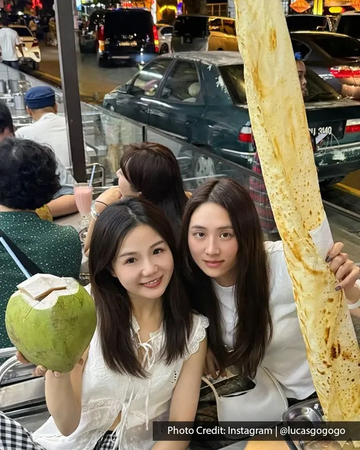 Two people posing with coconut and roti tissue.