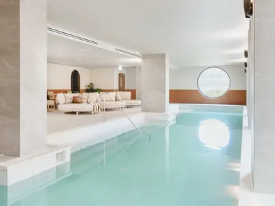 Indoor pool area with white couches and modern decor at Caulfield Place.