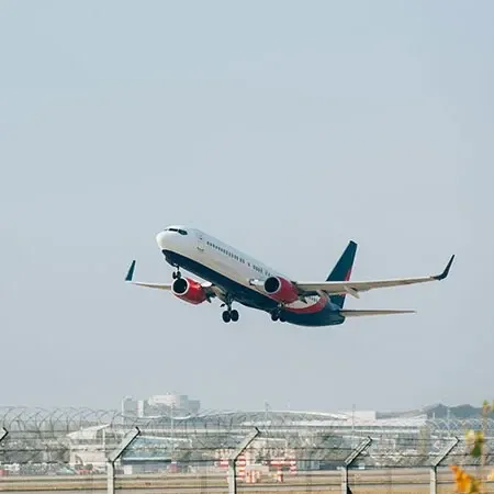 Commercial airplane taking off from airport runway under clear blue sky