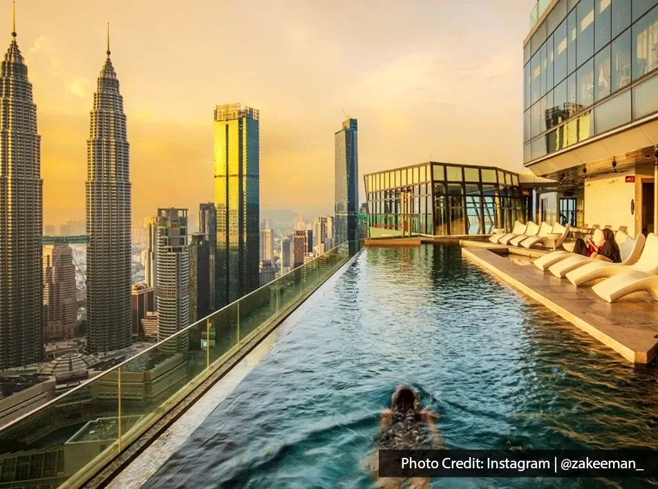 Guests relaxing at Imperial Lexis Kuala Lumpur infinity pool overlooking the city skyline