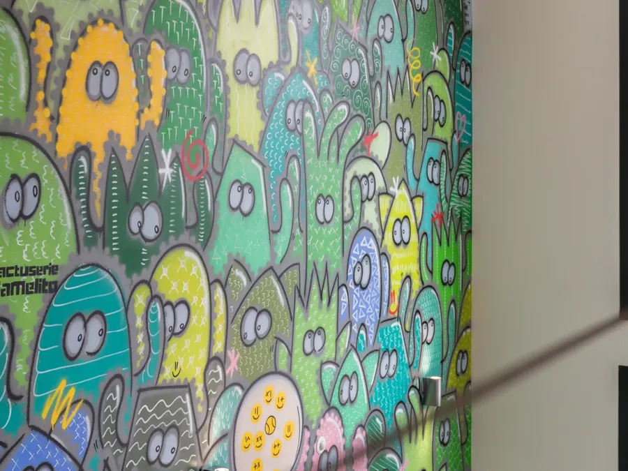 Bright and colorful cactus mural on a wall at Appart’Hôtel Hévéa.