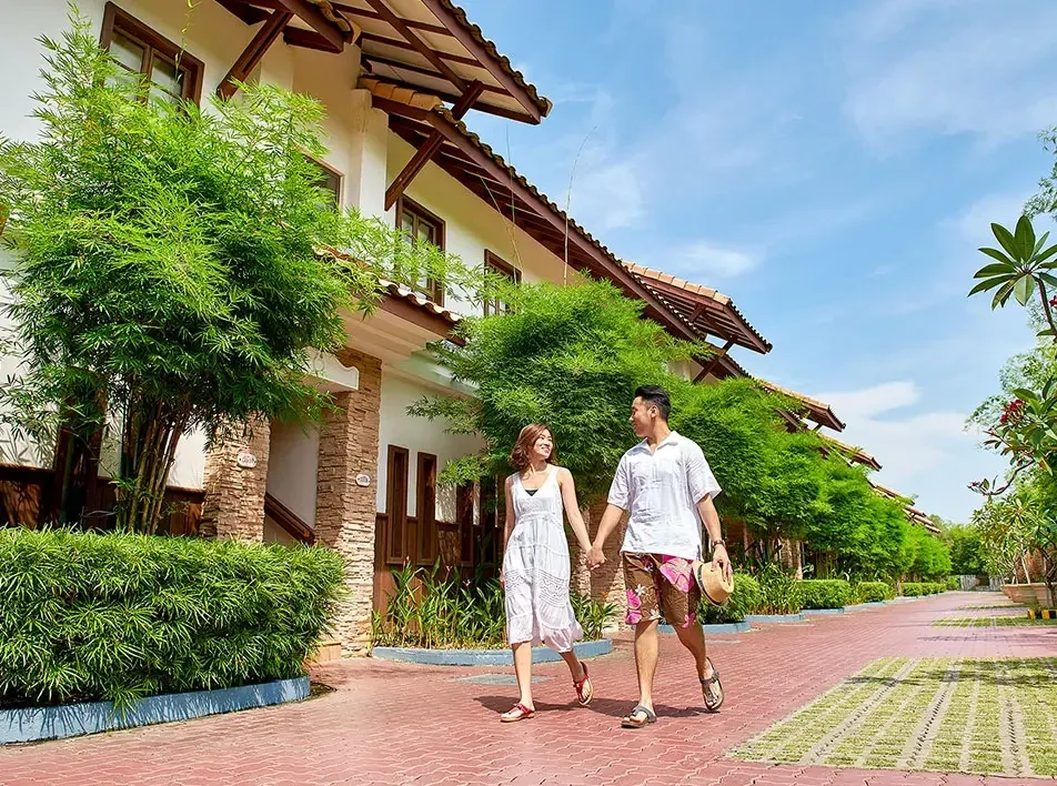 Couple holding hands while happily walking at a resort in Malaysia - Lexis MY