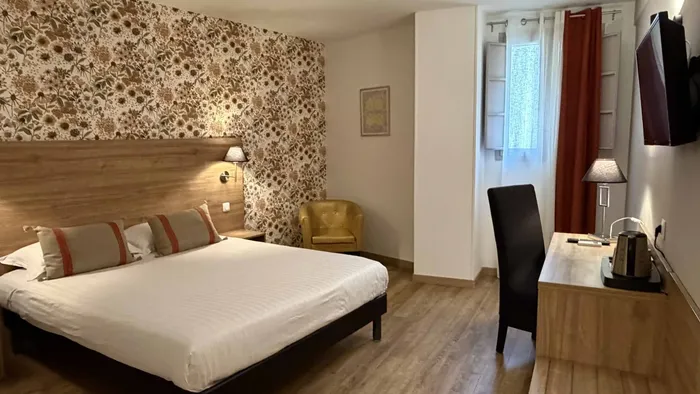 Chambre confortable avec lit, bureau et télévision au Grand Hôtel Molière.