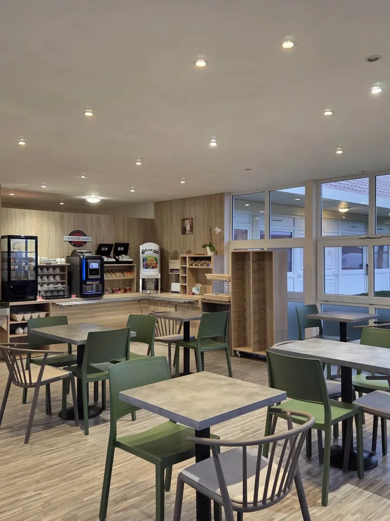 Salle du restaurant avec tables et chaises au Hôtel Aurillac Aéroport à Aurillac.