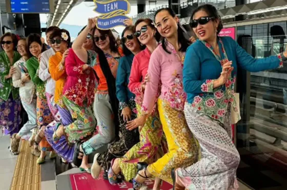 A diverse group of women in bright Nyonya kebayas pose happily for a picture - Imperial Lexis Kuala Lumpur