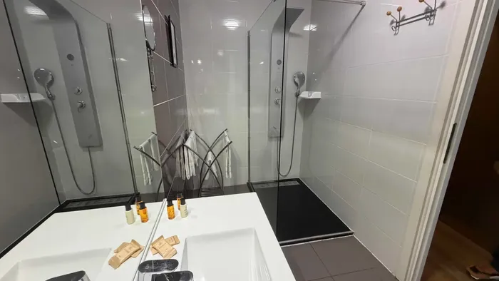 Salle de bain avec douche et baignoire à Le Grand Hôtel Molière.