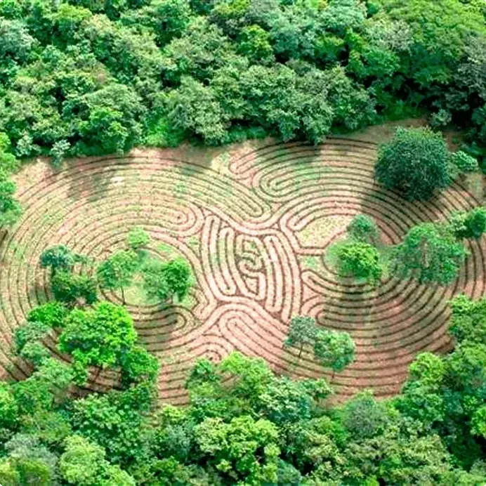 Vista aérea de un laberinto circular de piedra rodeado de exuberante vegetación tropical en Cala Luna Boutique Hotel