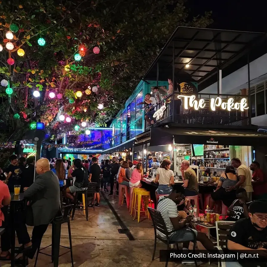 Crowded night scene with people dining and drinking at The Pokok – All Day Bar.