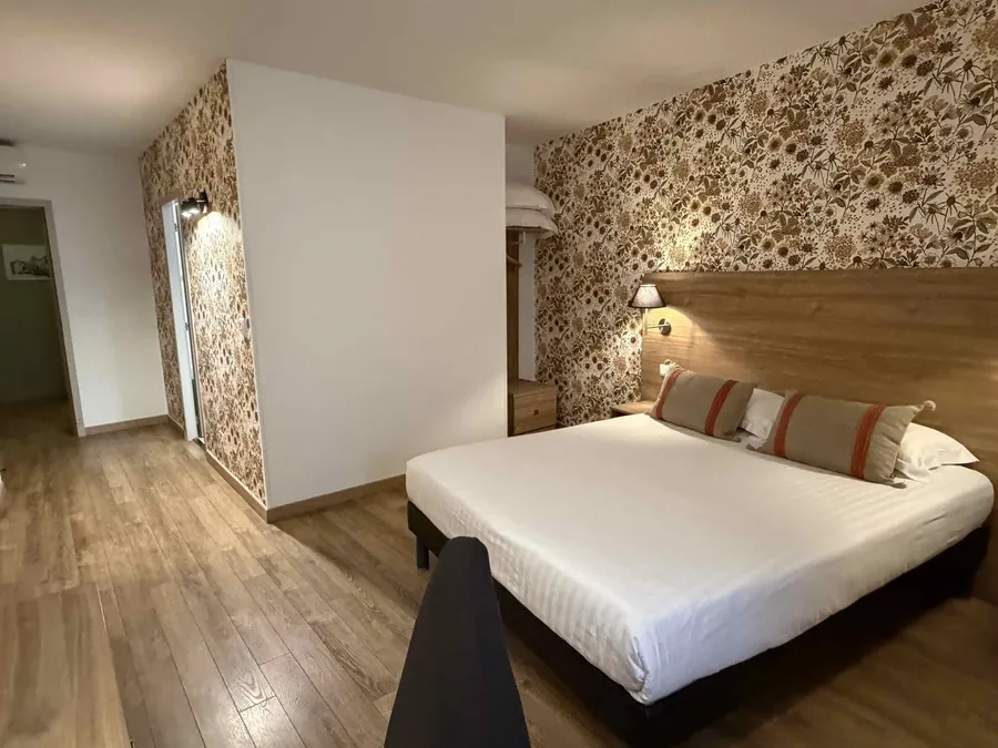 Chambre confort avec lit double et décor floral au Le Grand Hôtel Molière à Pézenas.