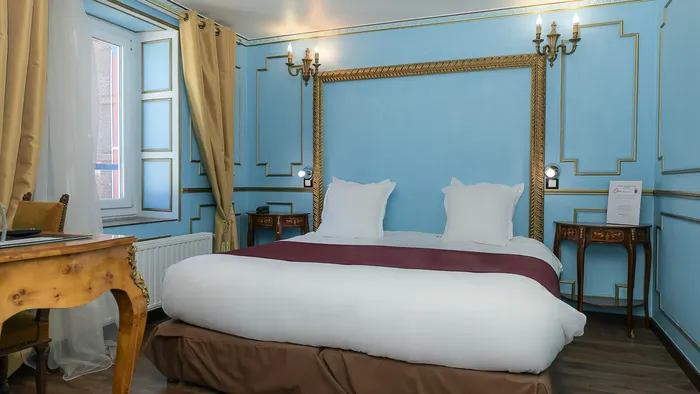 Chambre élégante avec lit et décoration bleue à l'Hôtel Villa Aultia.