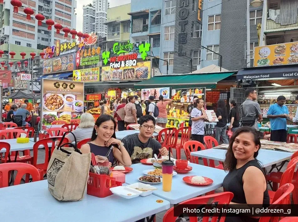 Group of friends enjoying food together at a food stall in kuala lumpur city.