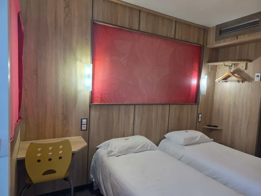 Chambre Standard Twin avec deux lits simples et décoration moderne à l'Hôtel Aurillac Aéroport.