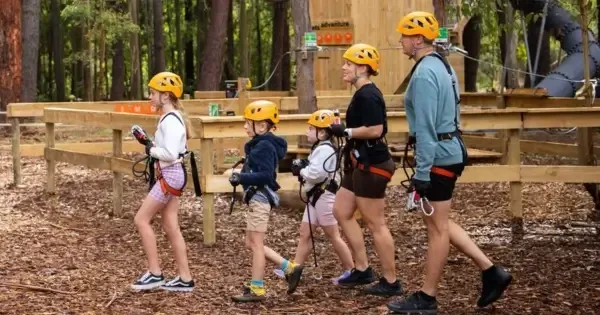 Family with children wearing safety gear preparing for high ropes course at TreeClimb Adelaide