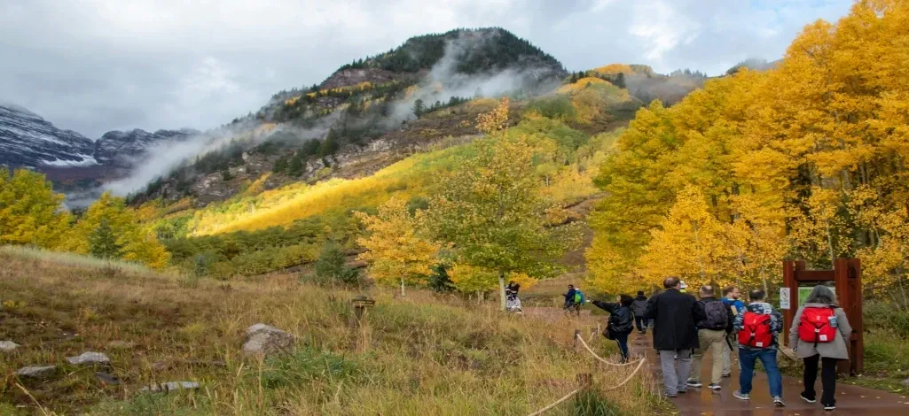 A group of people starting their ascent of Grotto Canyon on a fall day near Canmore.