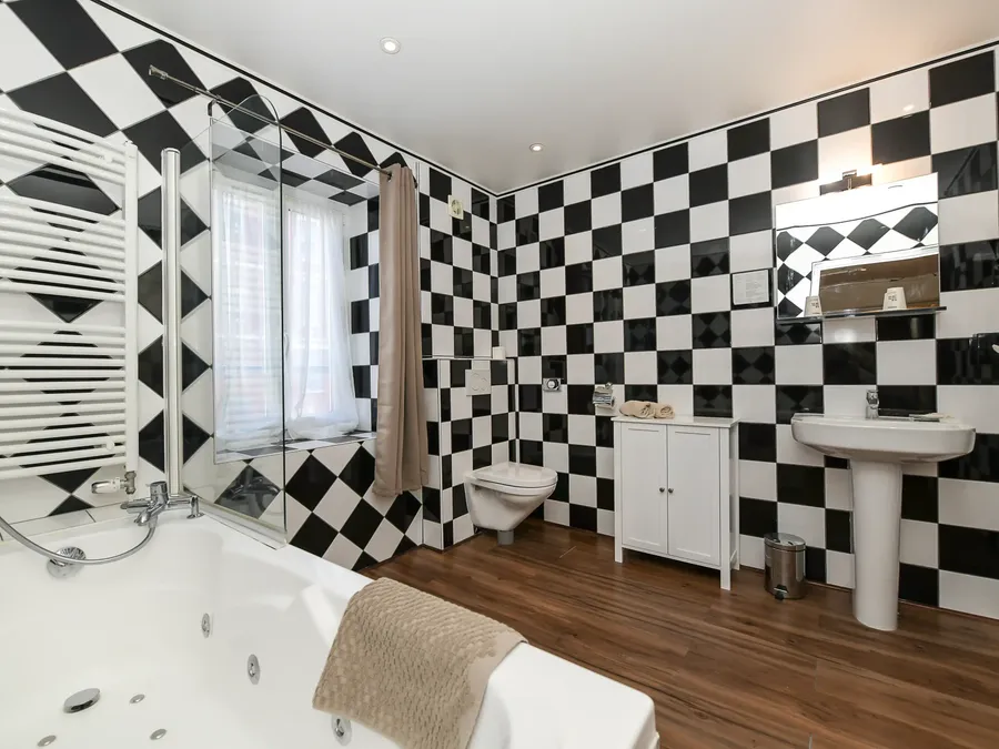 Salle de bain moderne avec baignoire et WC à la Suite Junior à l'Hôtel Villa Aultia à Ault.