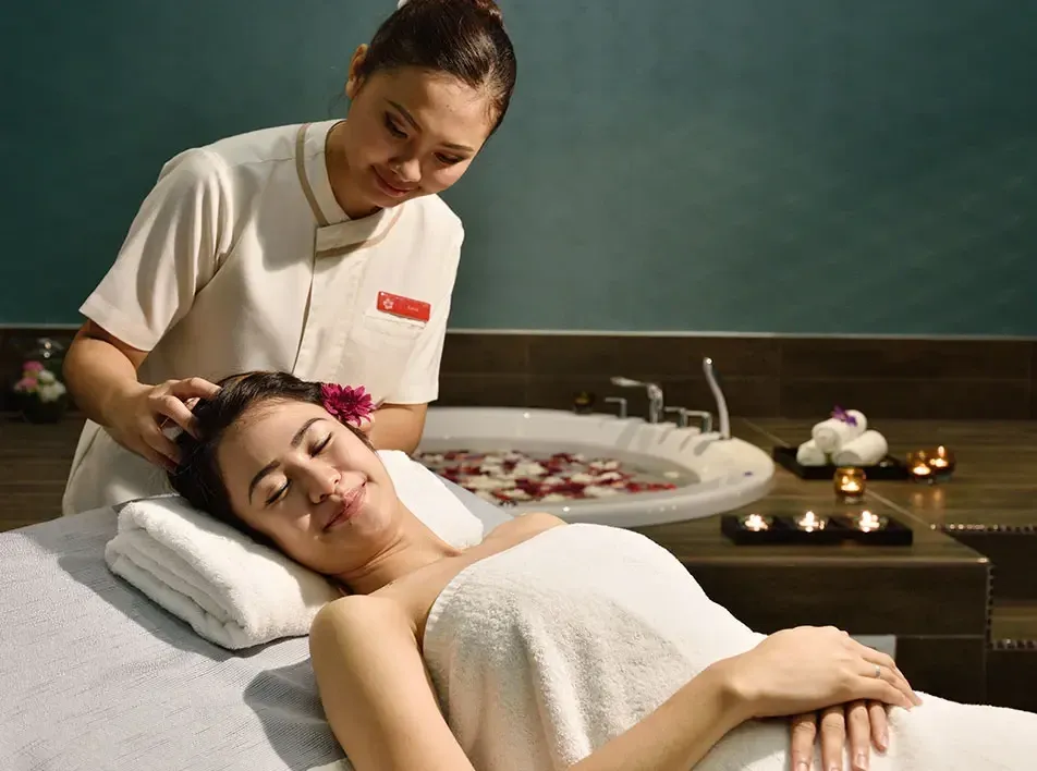 A lady receiving a head massage from trained professionals during her short vacation - Lexis MY