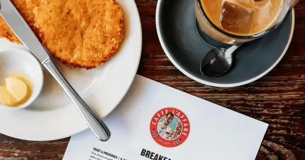 Coffee and hashbrown on plates with breakfast menu