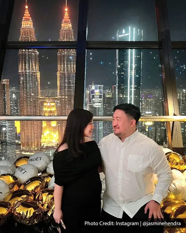 Couple smiling in front of Kuala Lumpur’s iconic skyline during their anniversary celebration.